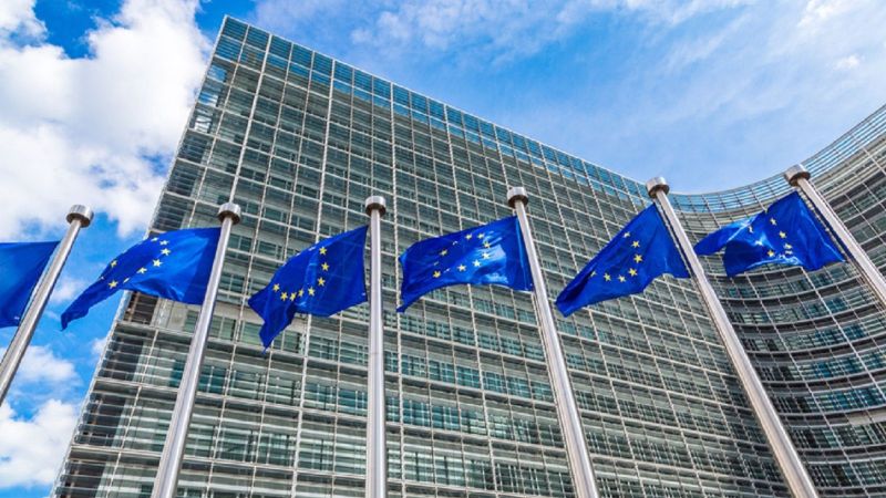 Fünf Fahnenständer jeweils mit der Europaflagge vor dem Gebäude der Europäischen Kommission in Brüssel.