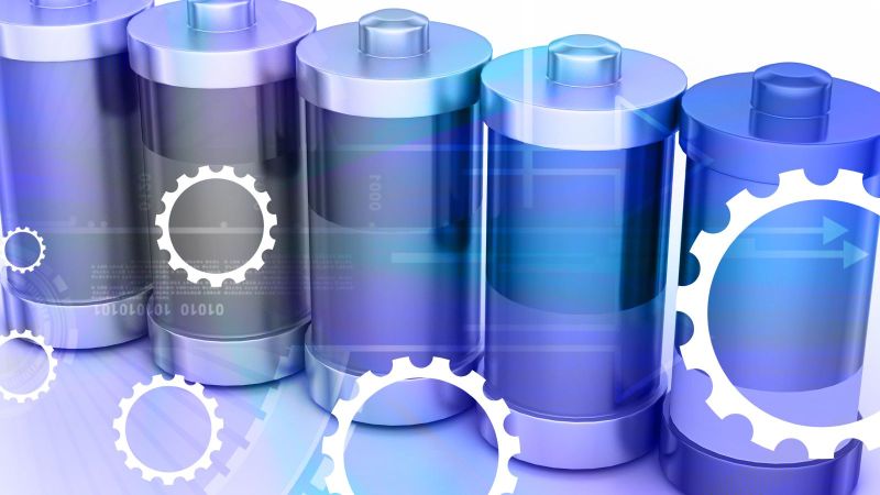Das Bild zeigt mehrere Batterien im Hintergrund; im Vordergrund Diagramme von Zahnrädern