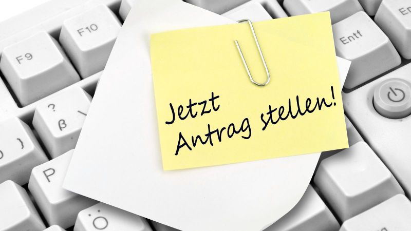 Graue Computertastatur mit gelbem Zettel mit der Aufschrift: 