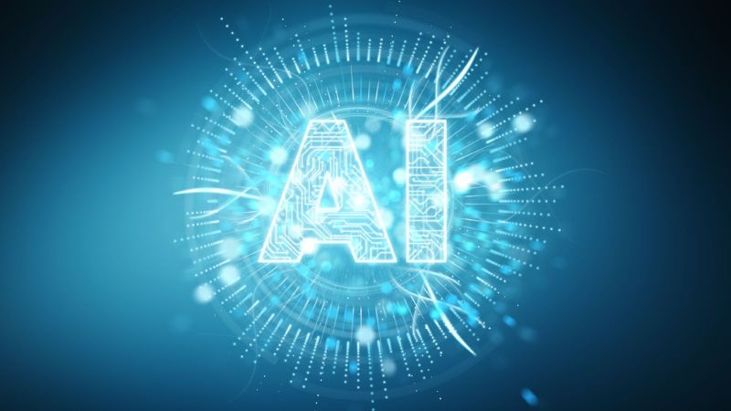 Blauer Hintergrund, vor dem in einem Kreis aus weißen Strichen der Begriff „AI“ in weiß steht.