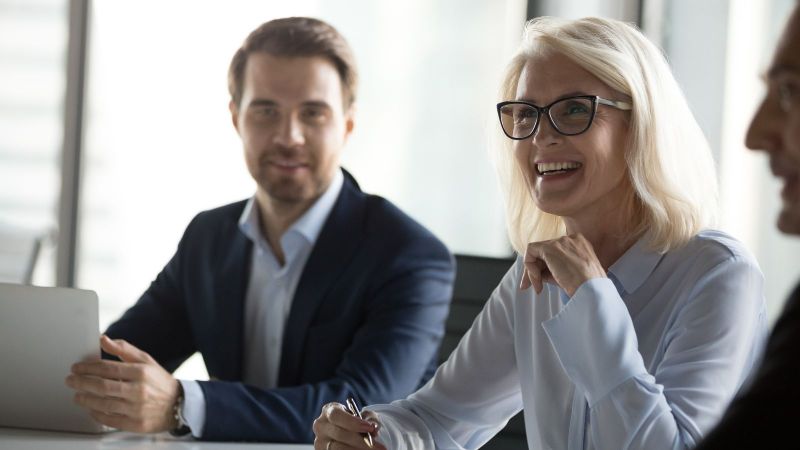 Eine Dame und ein Herr in Business Kleidung, die den Betrachter ansehen