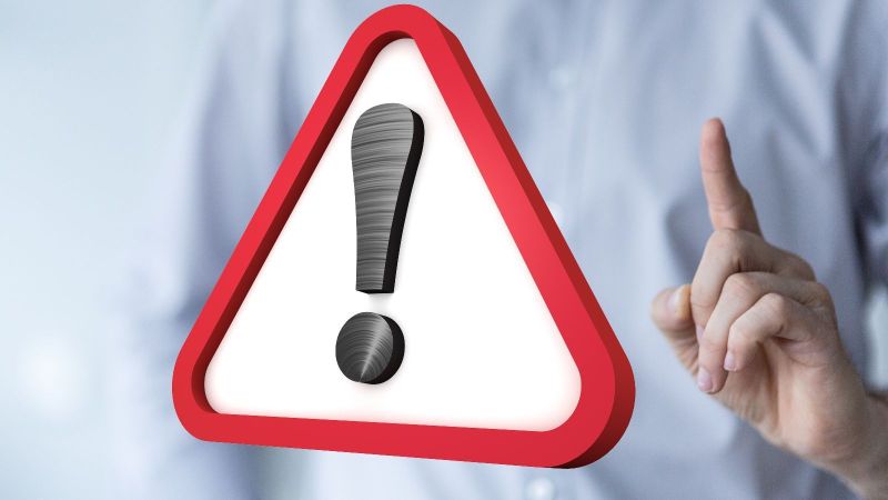 Schild mit Ausrufezeichen und daneben ein erhobener Zeigefinger