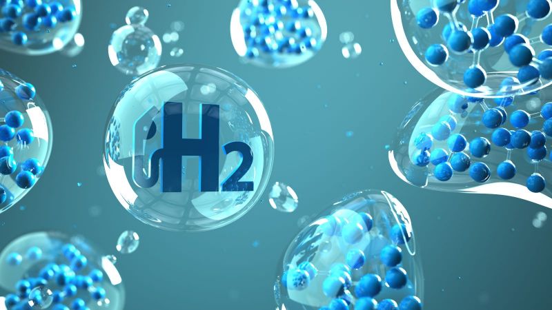 Das Bild zeigt Luftblasen mit verschiedenen Atomen und einer H2-Zapfanlage.