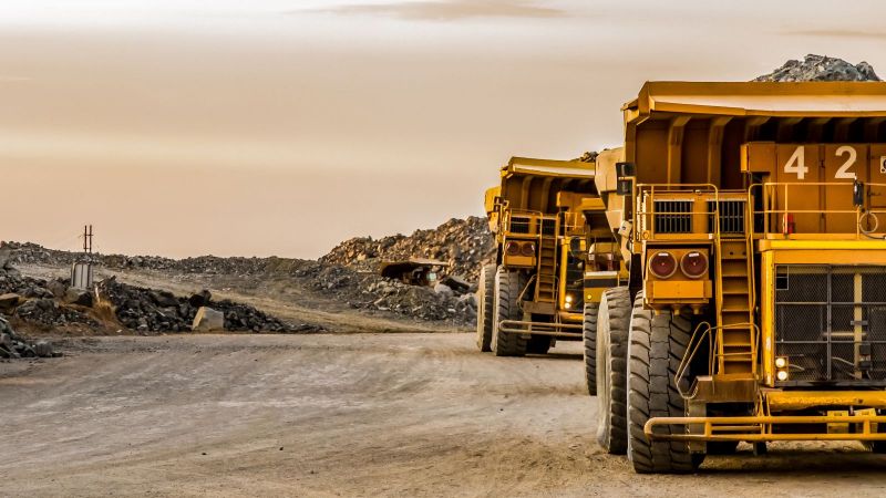 Gelbe Lastwagen fahren Steine von einer Mine weg