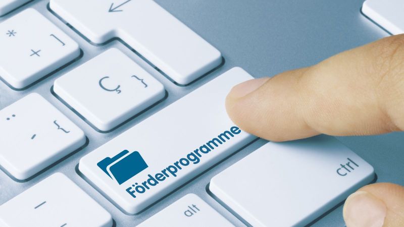 Finger auf Tastatur; Taste Förderprogramme