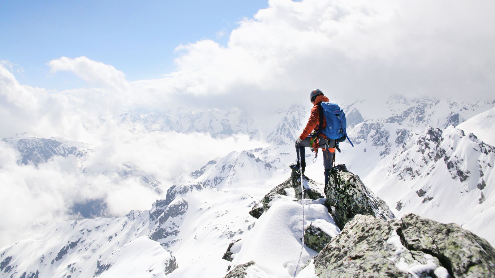 Das Bild zeigt eine Person auf einer Bergspitze.