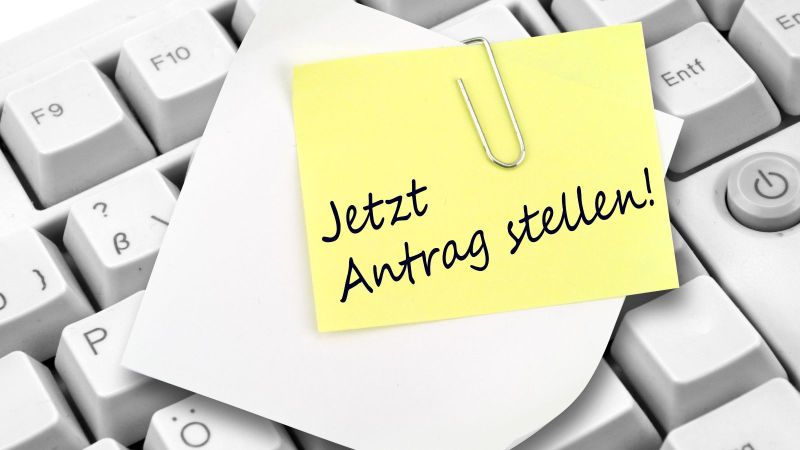 Tastatur mit Notizzettel und Büroklammer