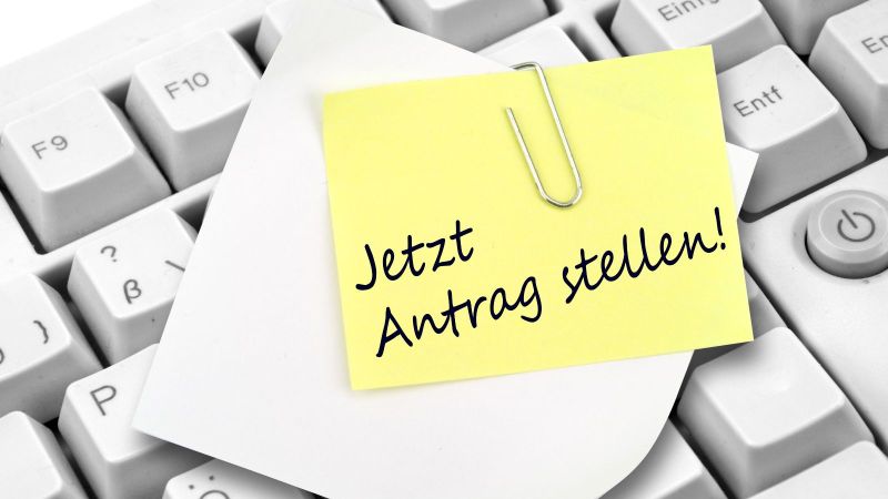 Tastatur mit Notizzettel und Büroklammer.