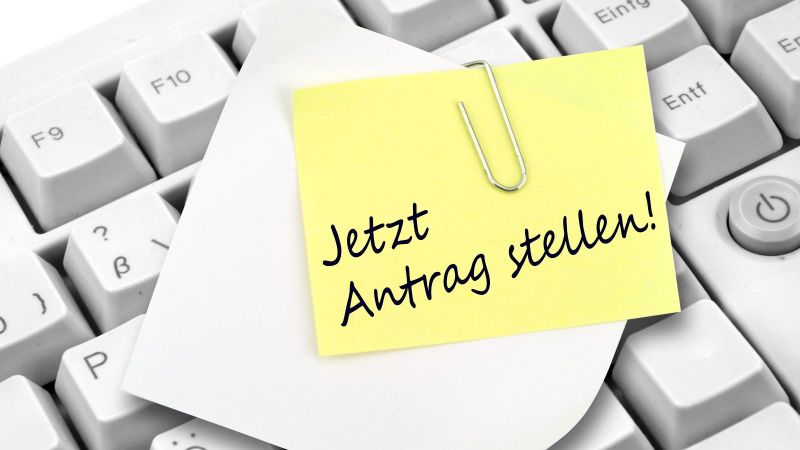 Tastatur mit Notizzettel und dem Text „Jetzt Antrag stellen!“ 