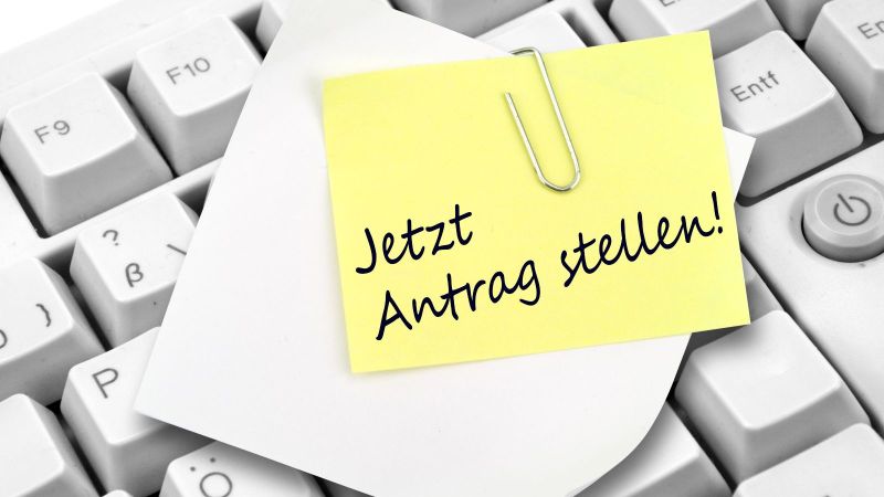 Das Bild zeigt eine Tastatur mit Notizzettel und Büroklammer.