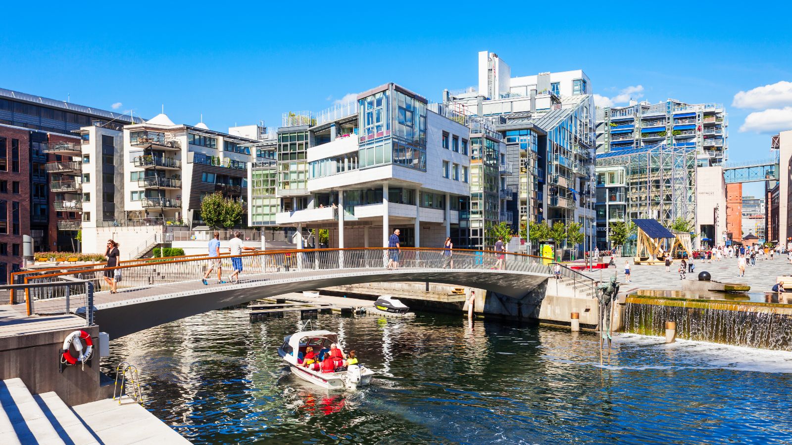 Das Bild zeigt eine Brücke über einen Fluss in einer modernen Stadt