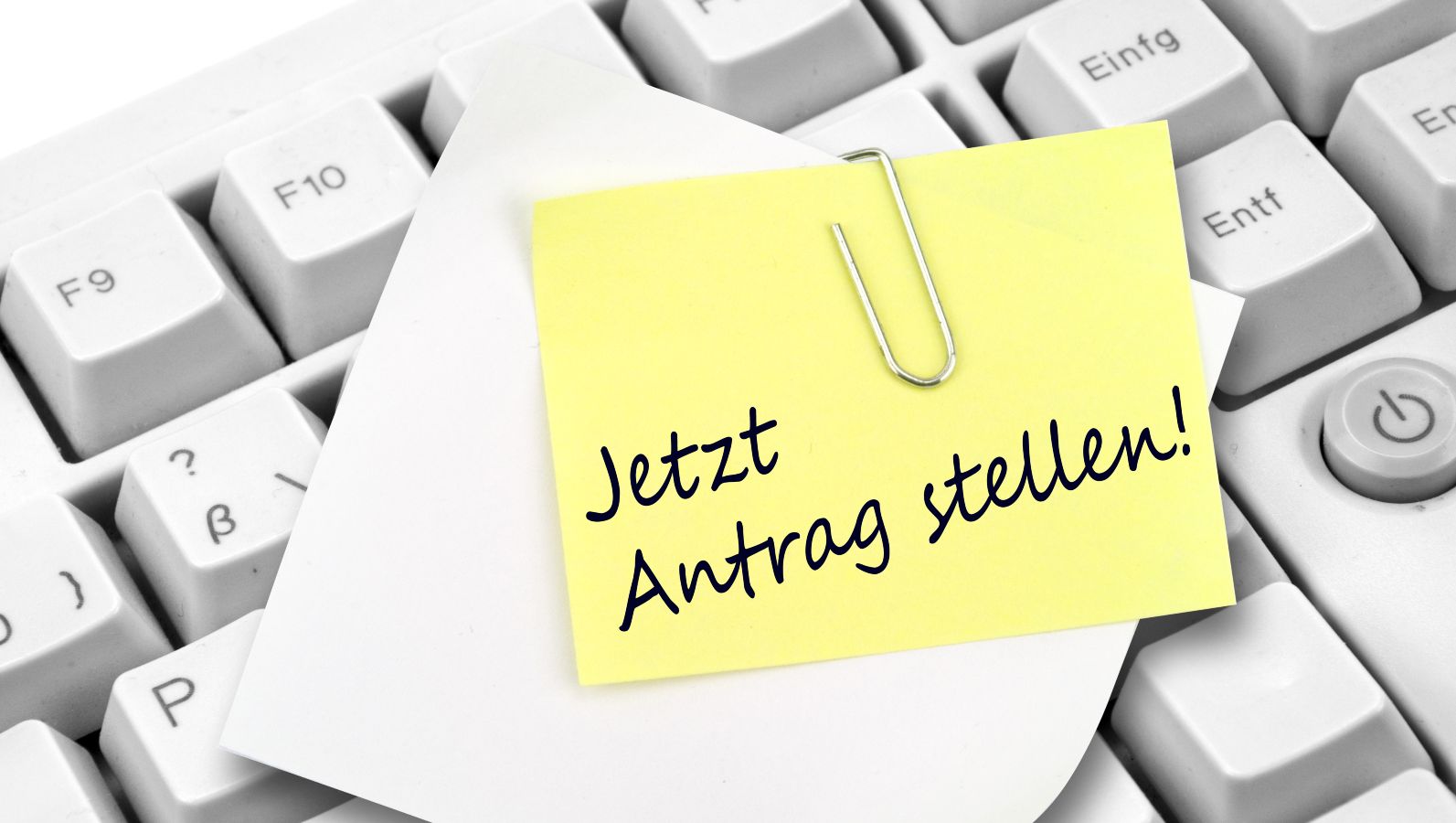 Tastatur mit Notizzettel und Büroklammer