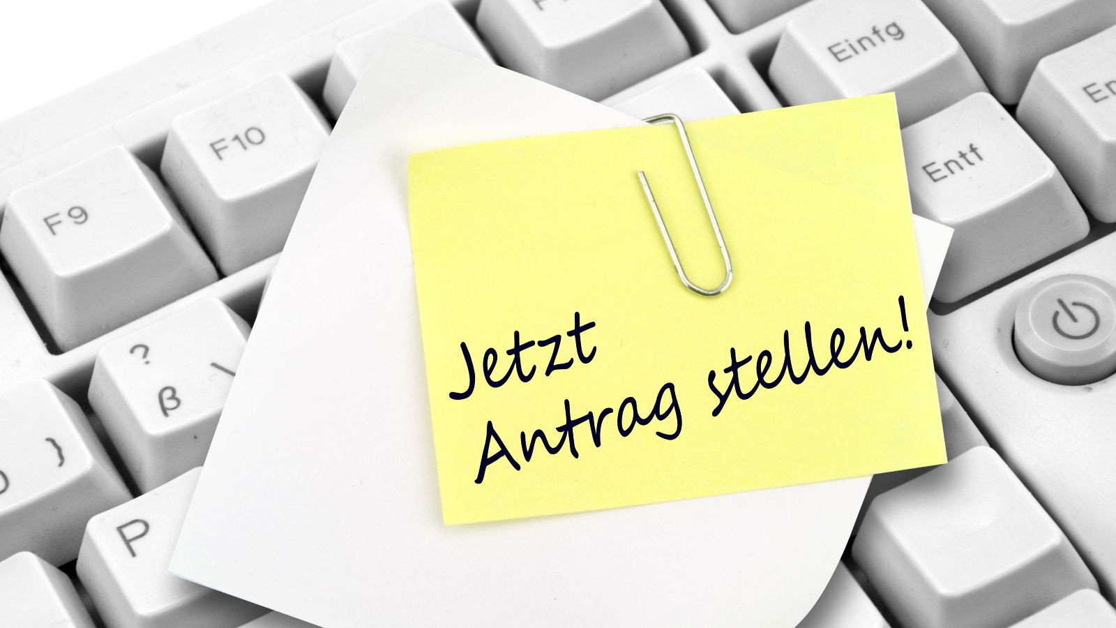 Tastatur mit Notizzettel und Büroklammer