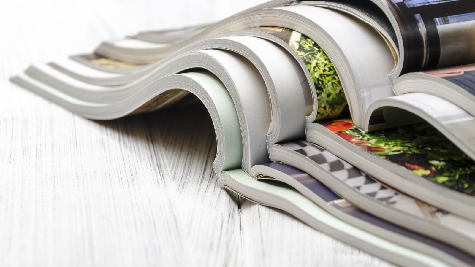 Diese Bild zeigt mehrere aufgeschlagene, ineinander gelegte Magazine.